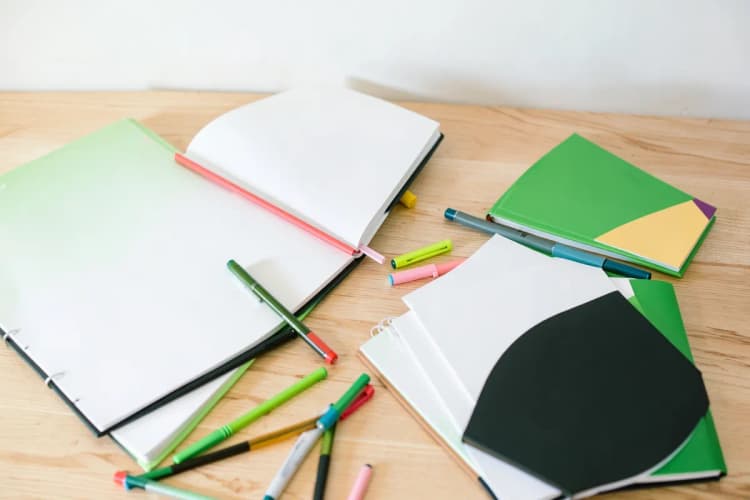 Um conjunto de diferentes materiais de estudo, como livros, canetas coloridas e um marca-texto, dispostos de forma a incentivar o aprendizado.